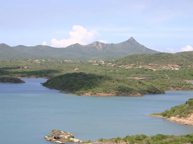 De Christoffelberg boven het groene landschap en een baai in het westen van Curaçao