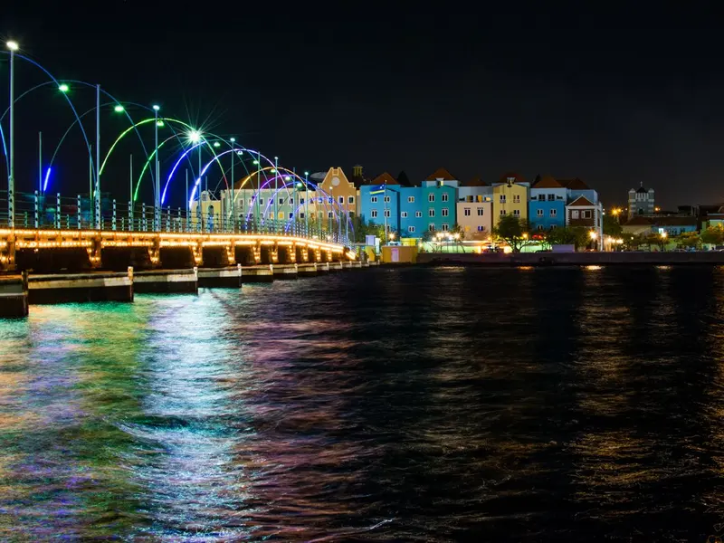 De verlichte Koningin Emmabrug en de gekleurde gevels van Willemstad bij avond