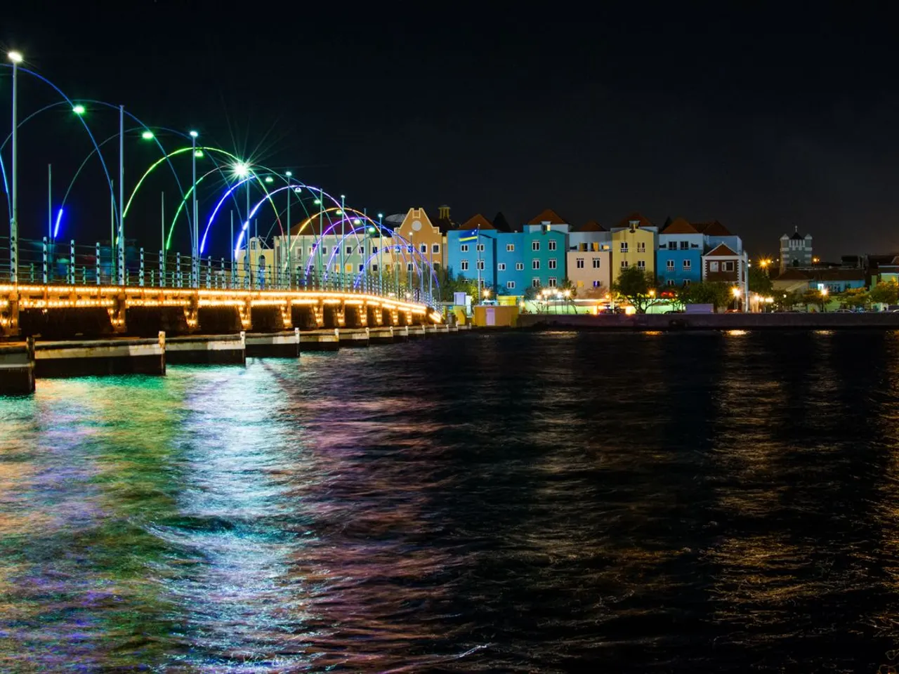 De verlichte Koningin Emmabrug en de gekleurde gevels van Willemstad bij avond