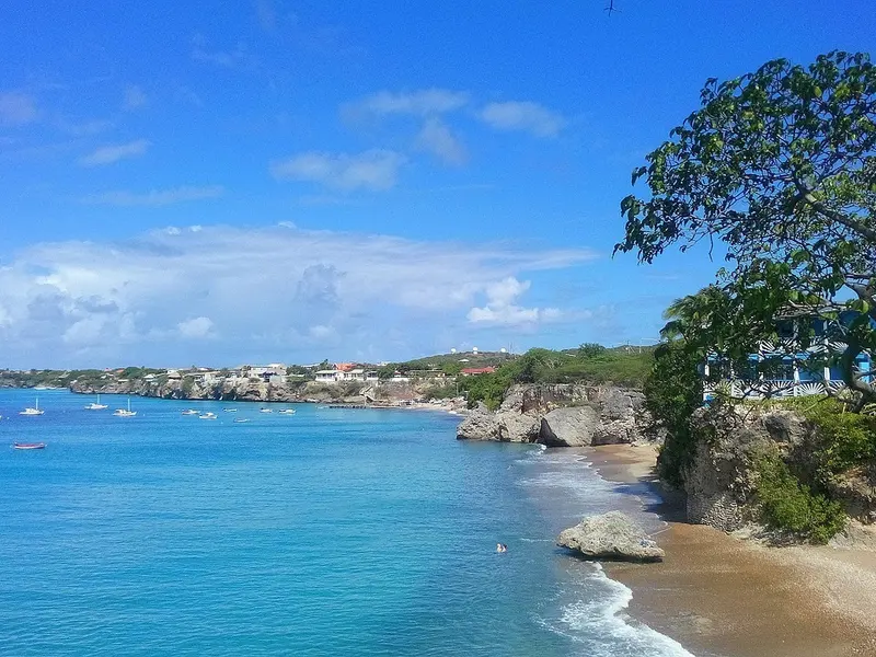 Baai met helderblauw water en rotsachtige kust aan de westkant van Curaçao