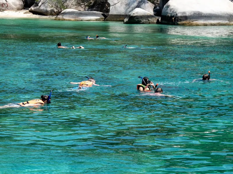 Snorkelaars in helder turquoise water bij de rotskust van Curaçao