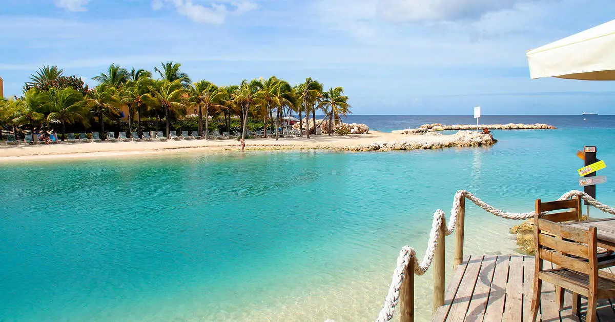 Turquoise lagune met palmen bij Mambo Beach